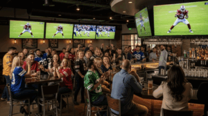 A wide-angle shot of a lively sports bar with people watching a game on TVs.