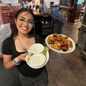 waitress holding wings and ranch