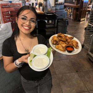 hostess with plate of chicken wings