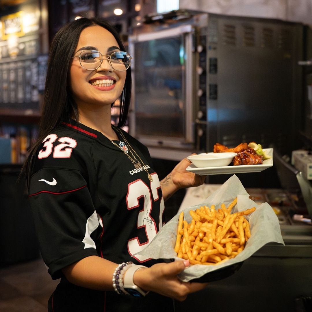 A waitress in a sports jersey serving food